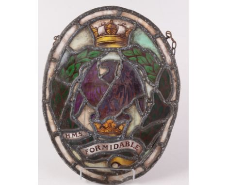 A stained glass and lead lined panel, inscribed 'H.M.S Formidable', decorated with crowns and an eagle, 34 x 26cm.