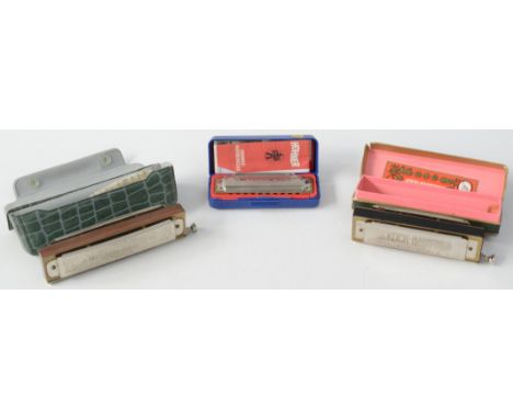 A Hohner 'Super Chromatic' harmonica, length 14cm, a German Koch chromatic harmonica and a M. Hohner blues harp, all cased. 