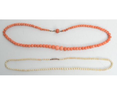 A pearl necklace with diamond set gold clasp and a coral necklace.