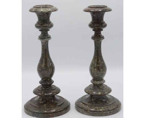 A pair of Cornish serpentine candlesticks, each with a turned baluster stem and circular stepped base, height 30cm.   Conditi