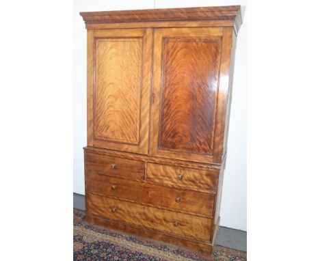 A linen press, the upper section with panel doors, the base with two short and two long drawers.