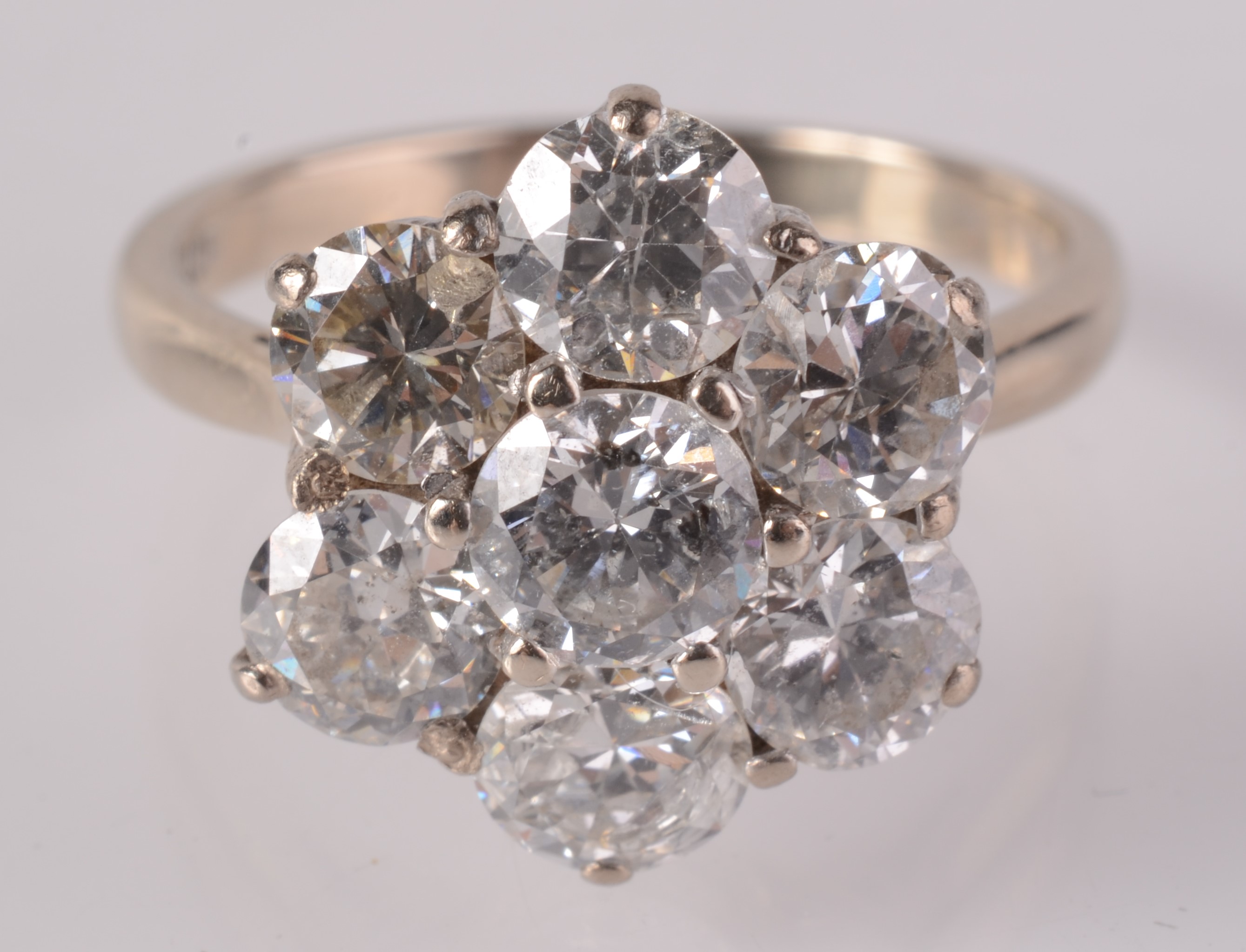 An impressive diamond seven stone flowerhead cluster ring set in 18ct