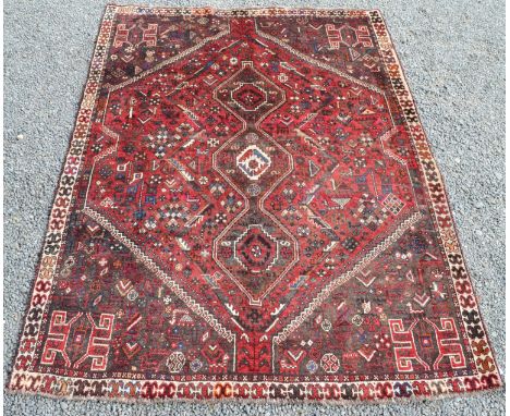 A Shiraz Persian carpet with a polychrome triple linked medallion, guls and animals, within an ivory hooked gul border, 243 x