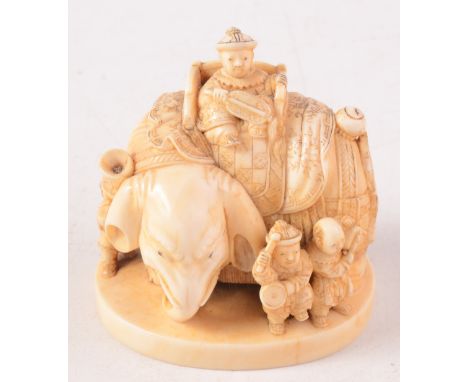 A Japanese ivory netsuke carved as an elephant standing four square and mounted with a throne style chair within which sits a