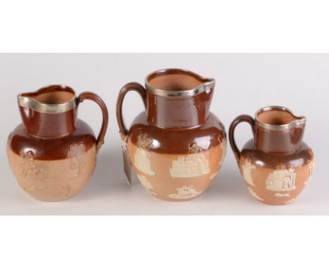 Two Doulton Lambeth silver banded jugs and a similar Royal Doulton jug, each decorated with hunting scenes, height of largest