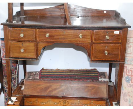 A Victorian mahogany and satinwood crossbanded desk with a drawer above an arch flanked by further drawers on square section 