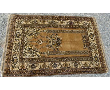 An Afghan rug, the camel mihrab with a pair of pillars flanking a central hanging floral spray, within an ivory arabesque bor