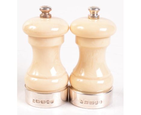 A pair of silver mounted salt and pepper mills simulating ivory. 