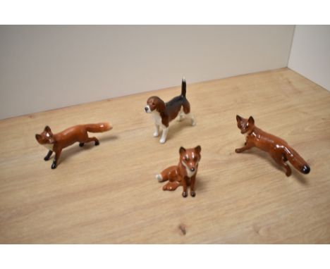 A group of three Beswick Pottery fox studies, comprising two fox standing number 1440 designed by Arthur Gredington in red/br