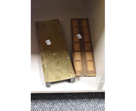 Two vintage cribbage boards, one of brass and the other of wood.
