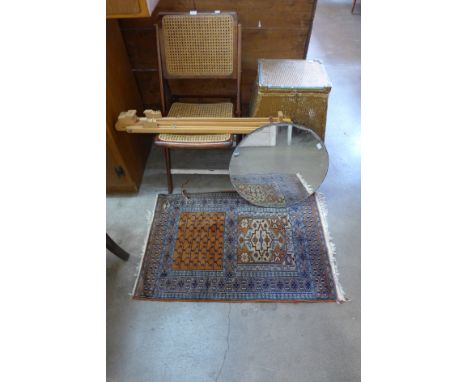 A Lloyd Loom linen box, folding chair, circular mirror, an artist's easel and a silk prayer mat