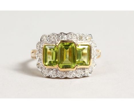 A 9CT GOLD THREE STONE PERIDOT AND DIAMOND RING.