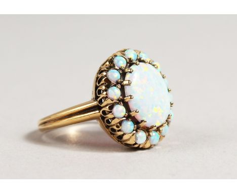 A 9CT GOLD OVAL OPAL CLUSTER RING.