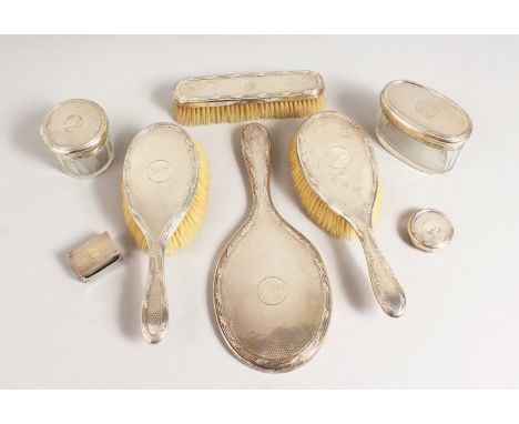 AN ENGINE TURNED SILVER BACK DRESSING TABLE SET, mirror, three brushes, two silver top bottles. London 1913.