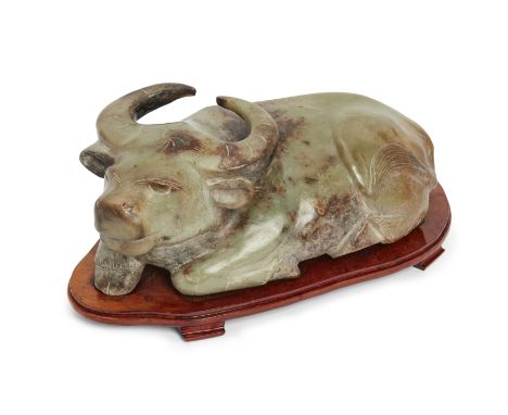 A massive Chinese jade buffalo,20th century,The recumbent buffalo carved with legs tucked under its body, 44cm long, on wood 