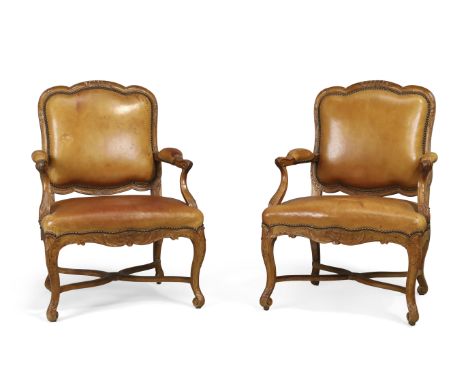 A pair of French walnut fauteuils, Of Regence style, first quarter 19th century, Each with carved frame and shaped back, with