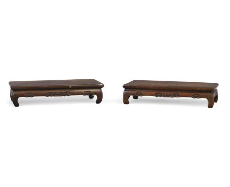 A pair of Chinese hongmu scholar&rsquo;s stands,Qing dynasty, 19th century,Each formed as a kang table carved with scroll mot