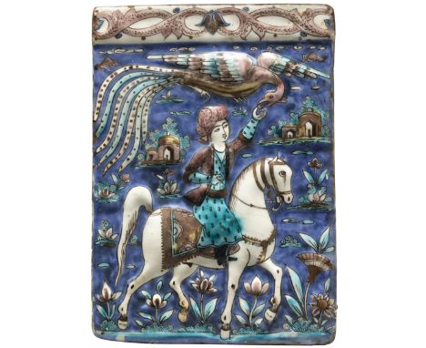 A polychrome moulded equestrian pottery tile, Tehran, Qajar Iran, c.1880, The rider reaching for and feeding a simurgh, amids