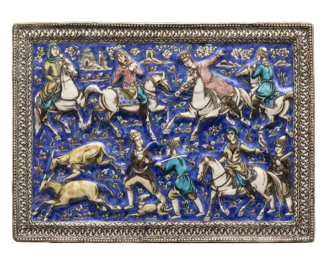 A large polychrome ochre and cobalt blue moulded pottery tile, Tehran, Qajar Iran, c.1880, Depicting Bahram Gur showing off h