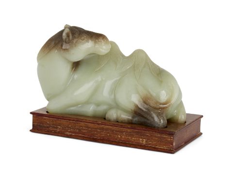 A Chinese Ming style celadon jade figure of a recumbent camel, 20th century, Carved with its head turned back toward its body