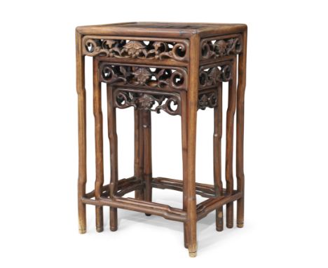 A Chinese hongmu nest of three occasional tables,Qing dynasty, 19th century,Each with reticulated scroll frieze on rounded st