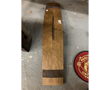A BATTERY OPERATED CLOCK MOUNTED ON A PIECE OF VINTAGE WOODEN BARREL WITH METAL BANDING DETAIL 