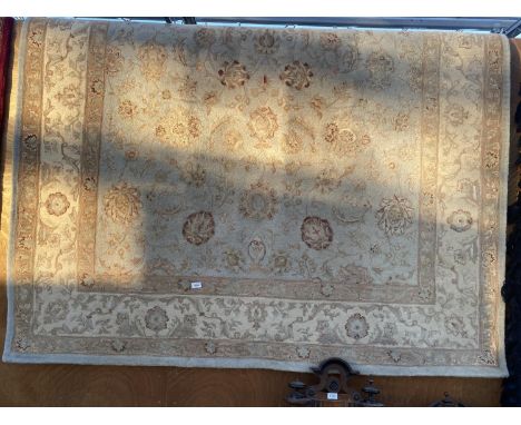 A LARGE CREAM AND LIGHT BLUE PATTERNED RUG 