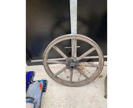 A VINTAGE WOODEN CART WHEEL WITH METAL OUTER BAND 