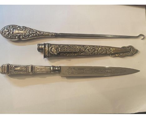 A HALLMARKED BIRMINGHAM SILVER HANDLED BUTTON HOOK AND A WHITE METAL KNIFE IN A DECORATIVE SHEATH 