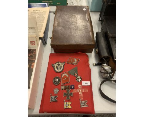 A SMALL VINTAGE LEATHER SUITCASE AND AN ASSORTMENT OF WAR MEDALS AND FABRIC MILITARY PATCHES 