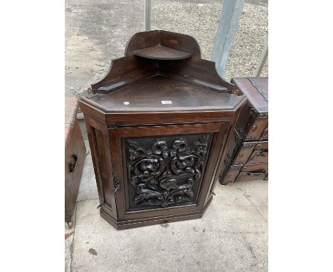 A LATE VICTORIAN OAK CORNER CUPBOARD WITH HEAVILY CARVED SINGLE DOOR AND SHAPED INTERIOR SHELF, 26" WIDE 