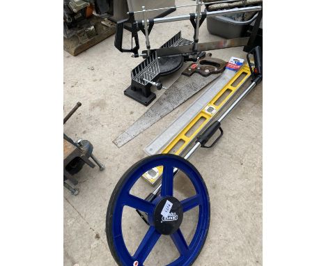 AN ASSORTMENT OF TOOLS TO INCLUDE A MITRE SAW, A MEASURING WHEEL AND A SPIRIT LEVEL ETC 