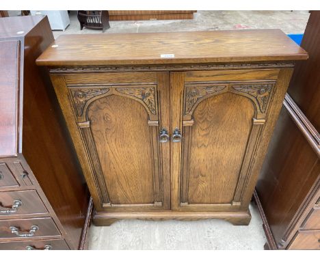 A LIGHT OAK OLD ABBEY STYLE TWO DOOR CD CABINET, 31" WIDE 