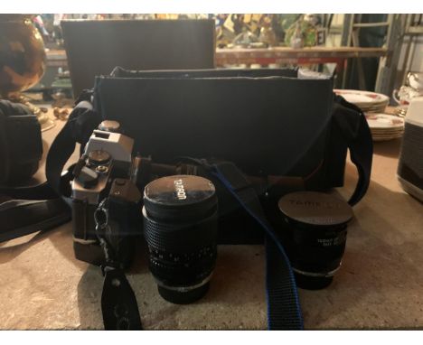 AN OLYMPUS OM 20 SELF TIMER CAMERA AND THREE TAMRON LENSES IN A CARRY CASE 