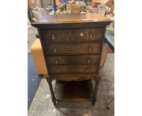 AN OAK MUSIC CABINET WITH FOUR FALL FRONT DRAWERS AND LOWER SHELF ON BARLEY TWIST SUPPORTS 