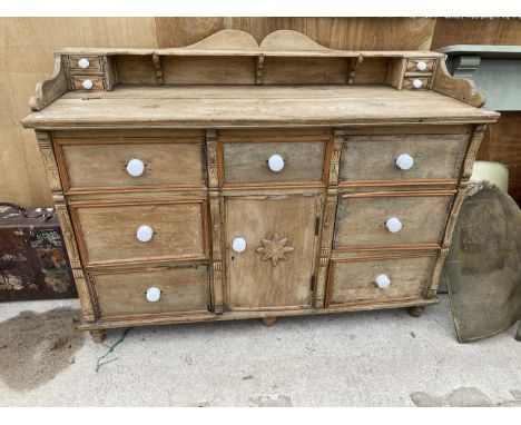A VINTAGE WOODEN KITCHEN DRESSER BASE ENCLOSING SEVEN DRAWERS AND ONE CUPBOARD 