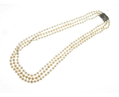Three-row freshwater pearl necklace to a diamond set panel clasp, stamped '750', shortest row approximately 48cm