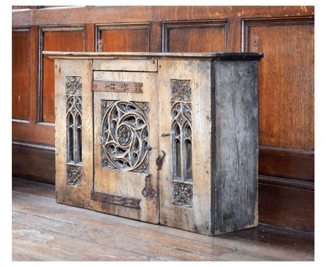 Boarded oak mural livery cupboard in the mid-16th Century manner, the central boarded door with pierced tracery rounded centr