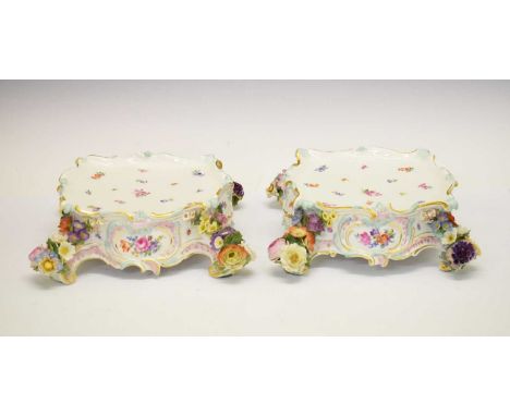 Pair of late 19th Century Meissen porcelain clock stands, of serpentine form with scrolling edges and applied flowers to the 