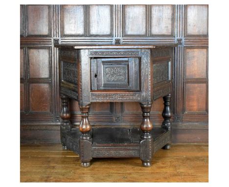 Charles I and later oak credence-type cupboard, the trapezoidal top over S-scroll carved and panelled door and conforming sid