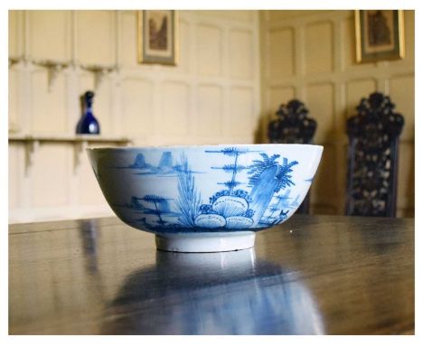 18th Century English delftware bowl, decorated with a waterside cottage, exotic plants, and islands, unmarked, 26cm diameter 