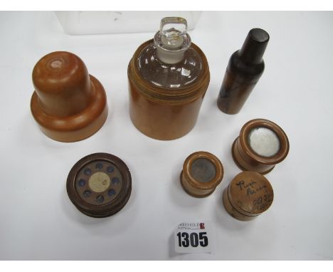 A XIX Century Glass Travelling Bottle in Treen Jar, by Gilbertson of London, 6cm diamater, tampons cylinders in original disc