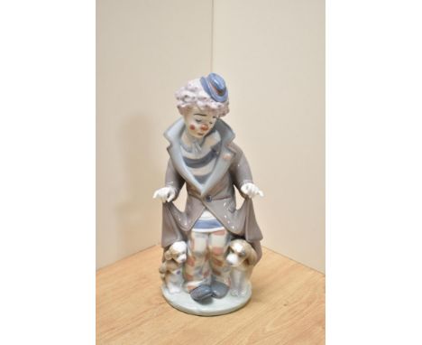 A Lladro porcelain clown group 'Suprise' number 5091, modelled as a forlorn clown revealing a dog and two puppies from under 