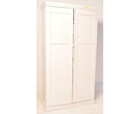 A vintage 20th century painted double door wardrobe. The wardrobe opening to reveal a bank of seven drawers raised on upright