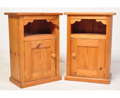 A pair of vintage 20th century country pine bedside cabinets. Each having an overhanging top with chamfered edge raised over 