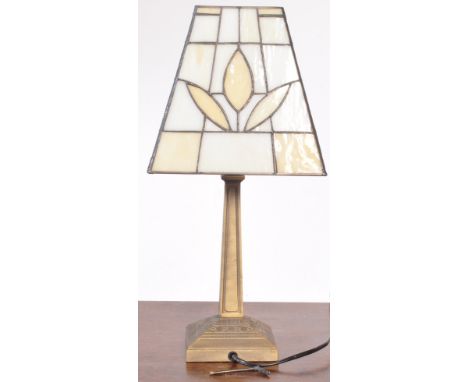 A vintage 20th century Tiffany style table lamp with glass and lead shade raised upon a decorative moulded plinth base. Measu