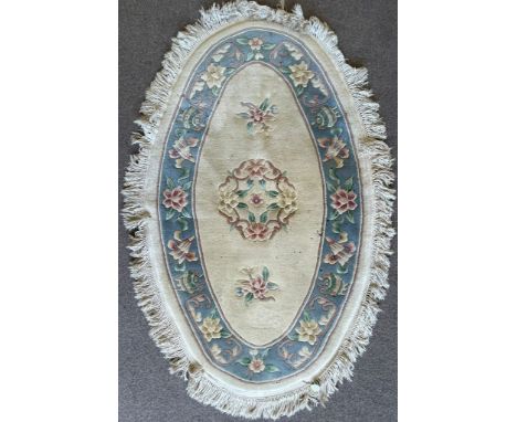 A vintage 20th century Chinese Oriental rug carpet of oval form&nbsp; having a cream background with foliate polychrome detai