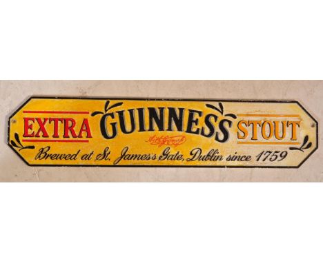 A vintage style cast iron Guinness Extra Stout sign. The sign reading "Guinness Extra Stout, Brewed at St. James`s Gate, Dubl