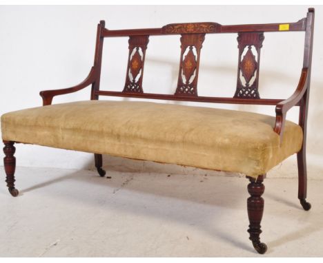 An early 20th century Edwardian mahogany inlaid sofa / love seat having a pierced three panel back rest, cushioned upholstere