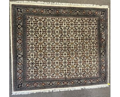 A 20th century Indian Oriental Hariki rug carpet having a finely detailed geometric motifs to the central panel set within a 